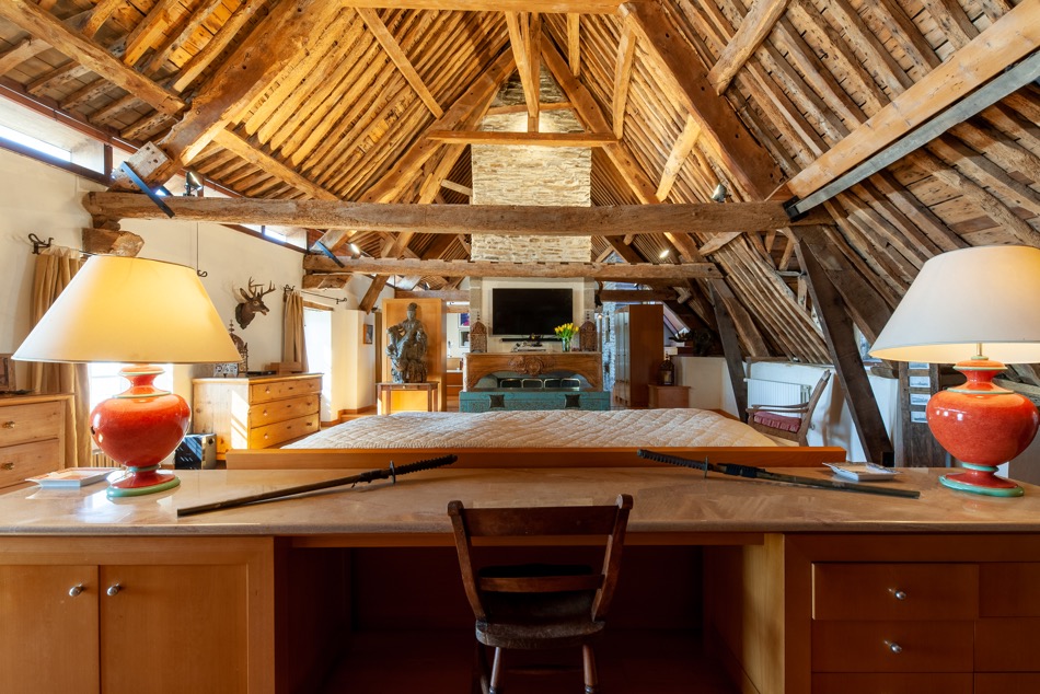 Chambre sous charpente apparente avec cheminée
